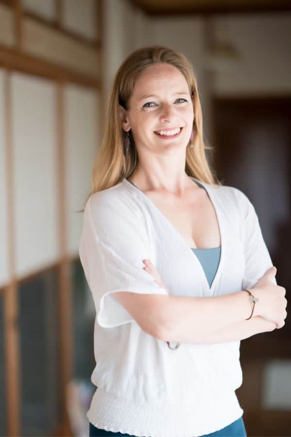 Ellie Smith Yoga Teacher Young woman standing with her arms folded smiling at the camera
